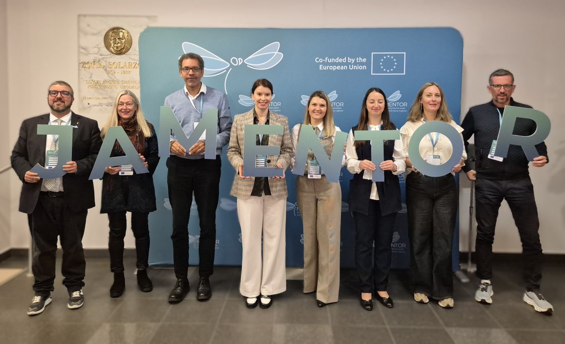 Participants of the conference holding cut out letters forming the word MENTOR