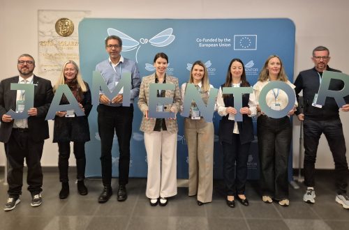 Participants of the conference holding cut out letters forming the word MENTOR