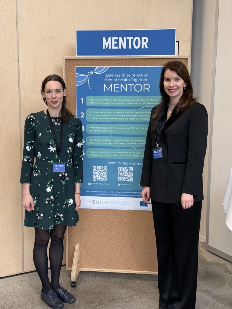 Photo of Sibilla Laura Neimane and Dr Liene Sile in front of the JA MENTOR poster.